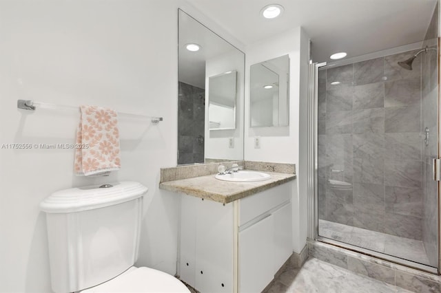 bathroom with a shower stall, toilet, and vanity