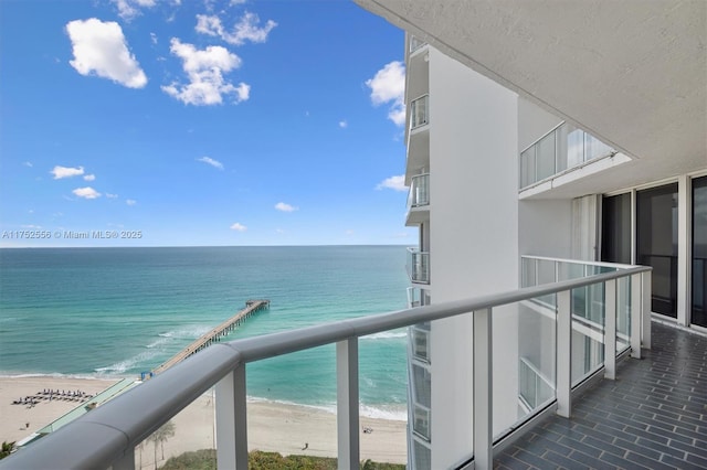 balcony with a water view and a beach view