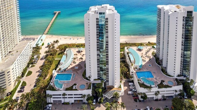 birds eye view of property featuring a water view and a beach view