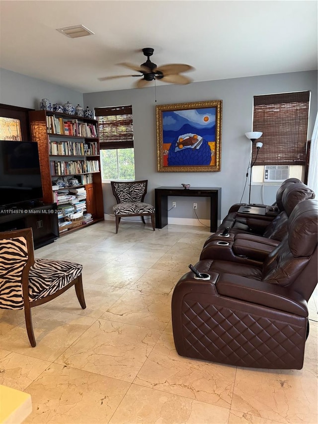 sitting room with ceiling fan, baseboards, and cooling unit