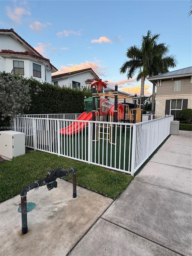 view of front of property featuring fence and a playground