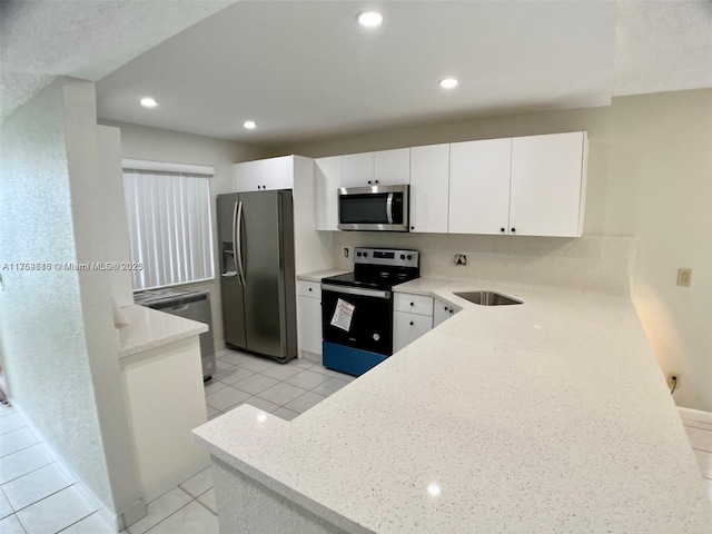 kitchen featuring appliances with stainless steel finishes, recessed lighting, white cabinets, and a peninsula