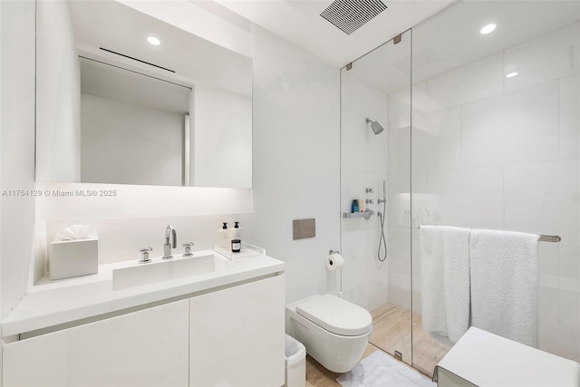 full bathroom featuring visible vents, vanity, toilet, and tiled shower