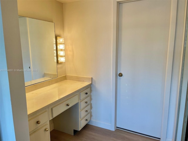 bathroom with vanity, baseboards, and wood finished floors