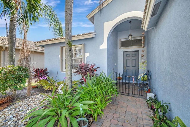 doorway to property with a tiled roof and stucco siding
