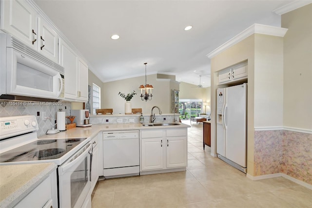 kitchen with a peninsula, white appliances, a sink, and crown molding