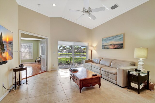 living area with baseboards, visible vents, crown molding, high vaulted ceiling, and light tile patterned flooring