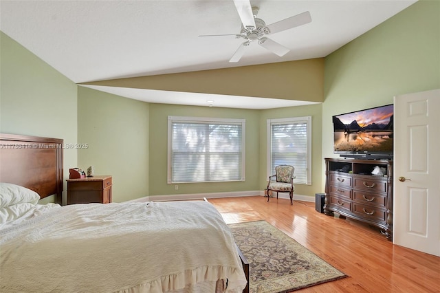 bedroom with lofted ceiling, ceiling fan, light wood-style flooring, and baseboards