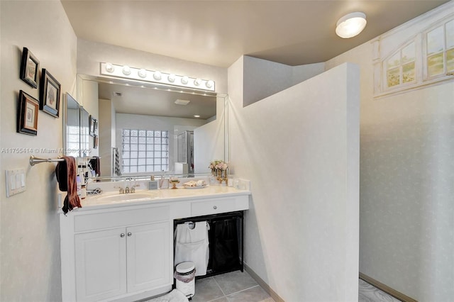 bathroom with walk in shower, tile patterned flooring, vanity, and baseboards