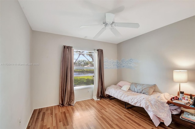 bedroom with ceiling fan, light wood finished floors, and baseboards