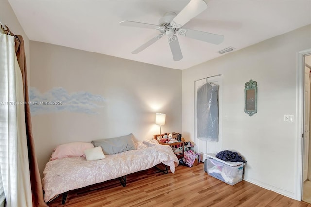 bedroom featuring light wood-style floors, visible vents, and ceiling fan
