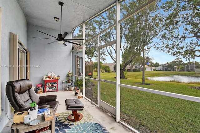 sunroom with a water view, plenty of natural light, and a ceiling fan
