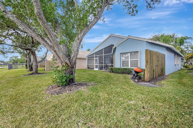 exterior space featuring stucco siding, a yard, and fence