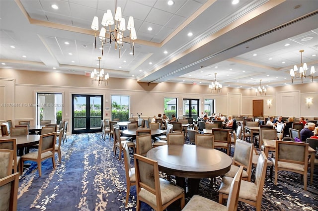 carpeted dining room with a towering ceiling, ornamental molding, french doors, a notable chandelier, and recessed lighting