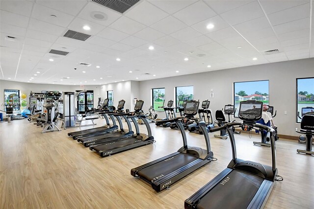 exercise room with light wood finished floors and visible vents