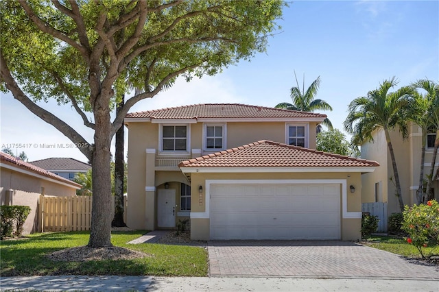 view of front of property with decorative driveway, stucco siding, an attached garage, fence, and a tiled roof