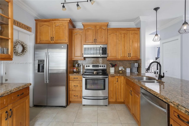 kitchen featuring stone counters, crown molding, appliances with stainless steel finishes, and a sink