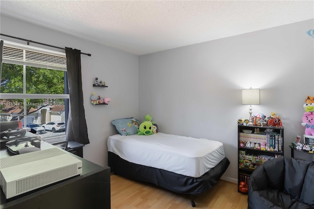 bedroom with a textured ceiling and light wood-style flooring