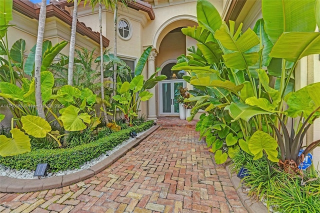 property entrance with stucco siding and french doors