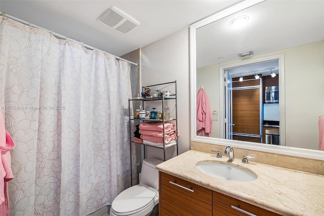 bathroom with visible vents, vanity, and toilet