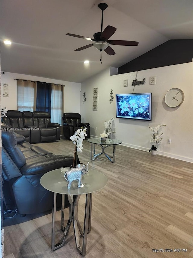 living area with ceiling fan, baseboards, wood finished floors, and lofted ceiling