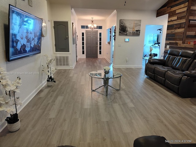 living room featuring wood finished floors, an inviting chandelier, baseboards, and visible vents
