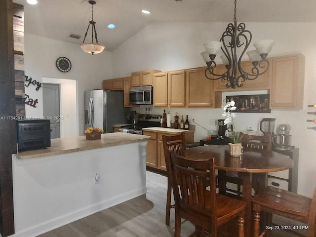 kitchen with decorative light fixtures, visible vents, appliances with stainless steel finishes, high vaulted ceiling, and wood finished floors