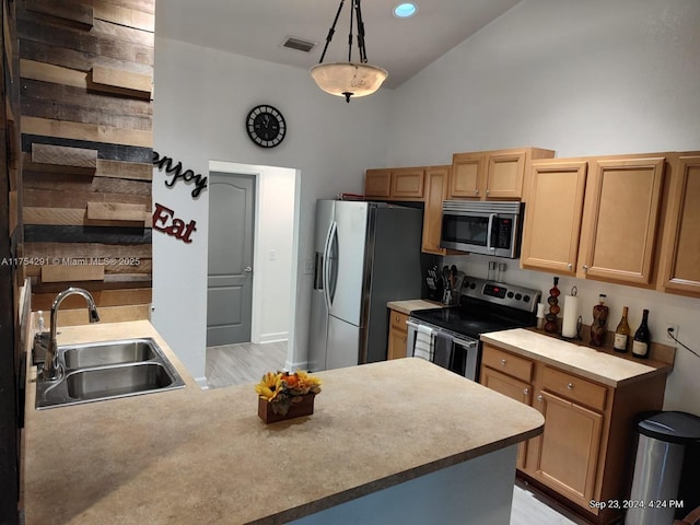 kitchen with a peninsula, visible vents, appliances with stainless steel finishes, light countertops, and a sink