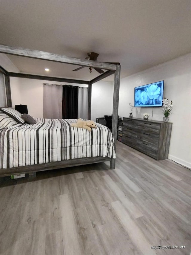 bedroom featuring ceiling fan, wood finished floors, and baseboards