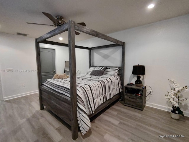 bedroom with visible vents, baseboards, and wood finished floors