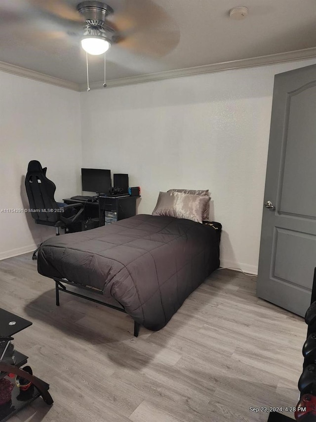 bedroom with wood finished floors, ceiling fan, baseboards, and ornamental molding