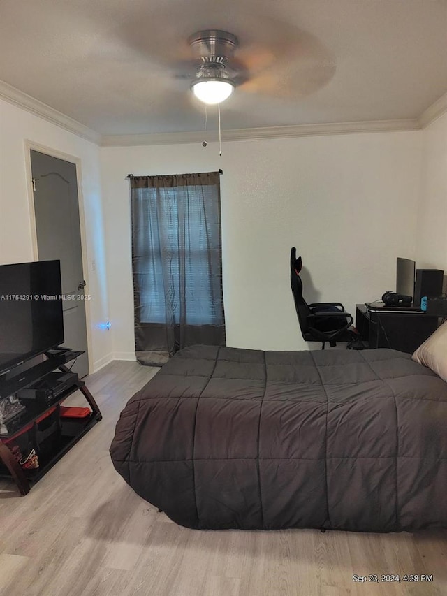 bedroom with crown molding, wood finished floors, baseboards, and a ceiling fan