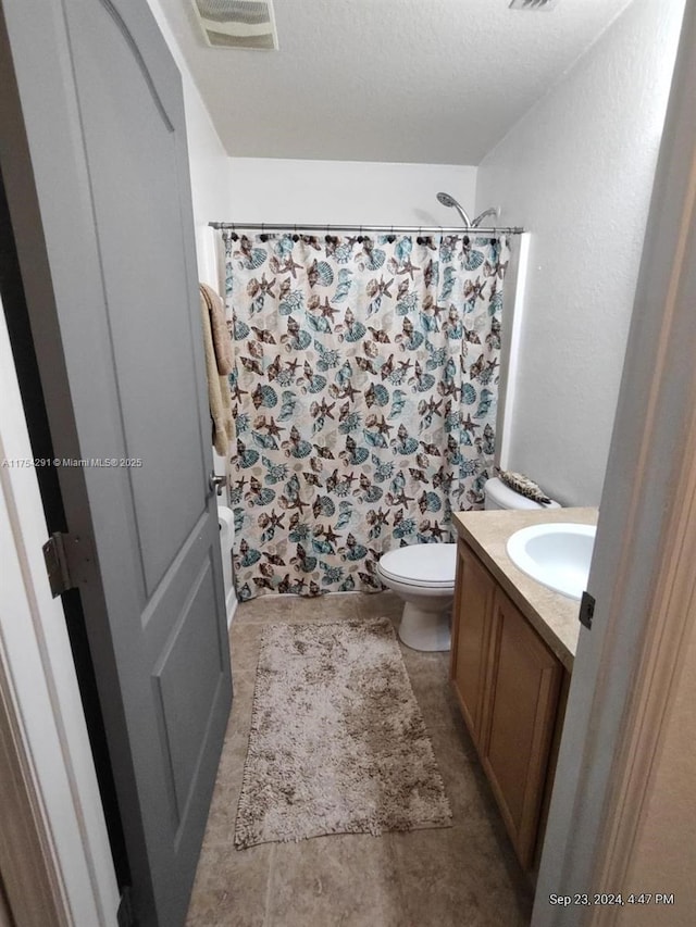 bathroom featuring toilet, vanity, a shower with shower curtain, and visible vents