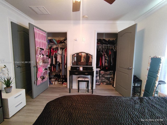 bedroom featuring wood finished floors, ornamental molding, and a spacious closet