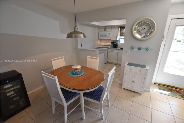 dining area featuring light tile patterned floors, plenty of natural light, and wine cooler