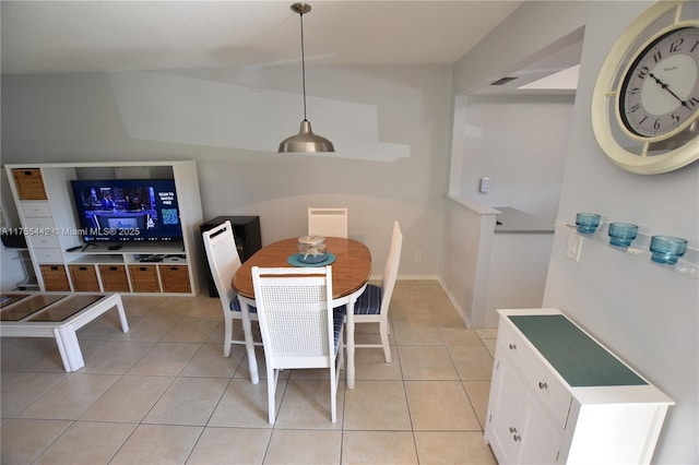 dining area with visible vents, vaulted ceiling, and light tile patterned flooring