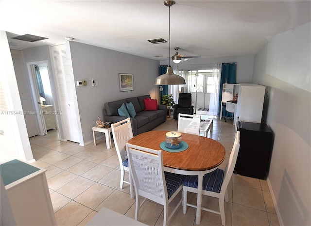 dining room featuring visible vents, ceiling fan, baseboards, and light tile patterned floors