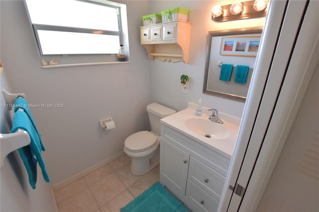 bathroom featuring baseboards, vanity, toilet, and tile patterned floors