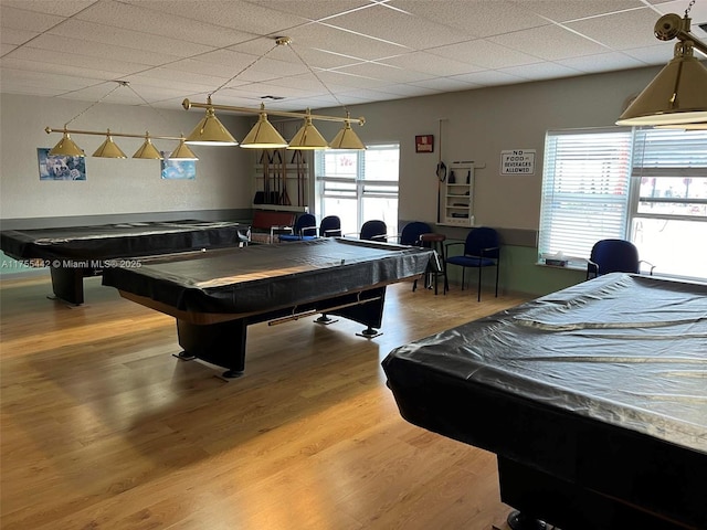 rec room with a paneled ceiling, wood finished floors, and pool table