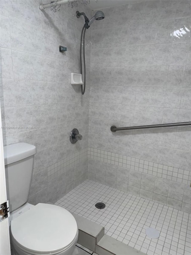 bathroom featuring toilet and a stall shower