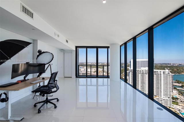 tiled office with expansive windows, plenty of natural light, visible vents, and a city view