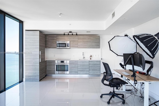 office area featuring visible vents, a wall of windows, a sink, and light tile patterned flooring