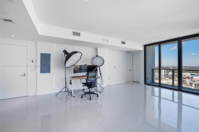 office area with a wall of windows, visible vents, and electric panel