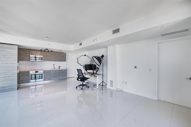 exercise room featuring light tile patterned floors, a sink, and visible vents