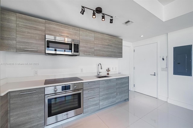 kitchen featuring electric panel, visible vents, modern cabinets, appliances with stainless steel finishes, and a sink