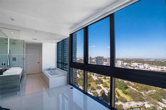 bathroom featuring a city view, a shower stall, vanity, a bath, and tile patterned floors