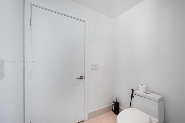 bathroom featuring toilet, baseboards, and tile patterned floors