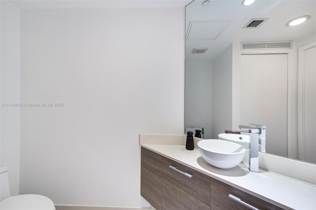 bathroom with recessed lighting, visible vents, vanity, and toilet