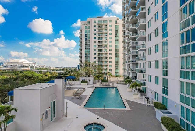 view of swimming pool featuring a view of city and a patio