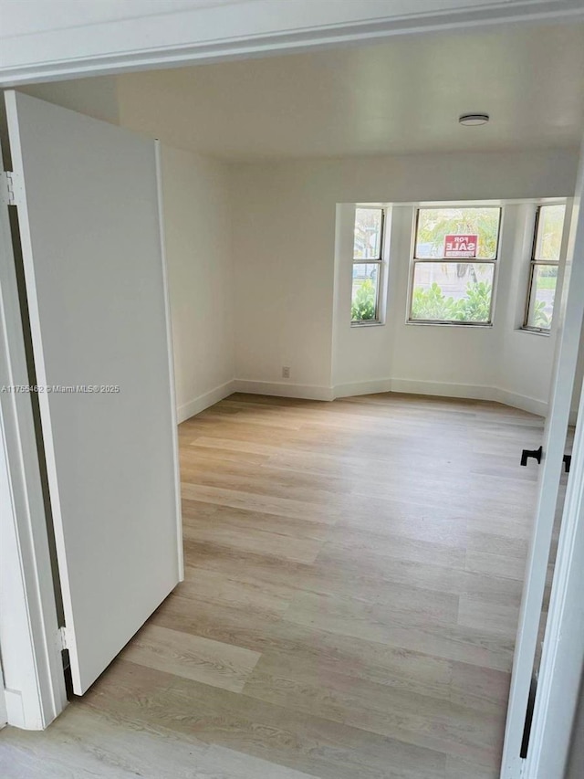 empty room featuring light wood-style floors and baseboards